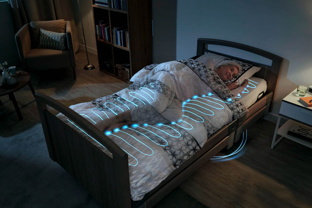 Schlafende Frau liegt in einem Pflegebett, die Sensoren der Hallòw-Matratze werden dargestellt